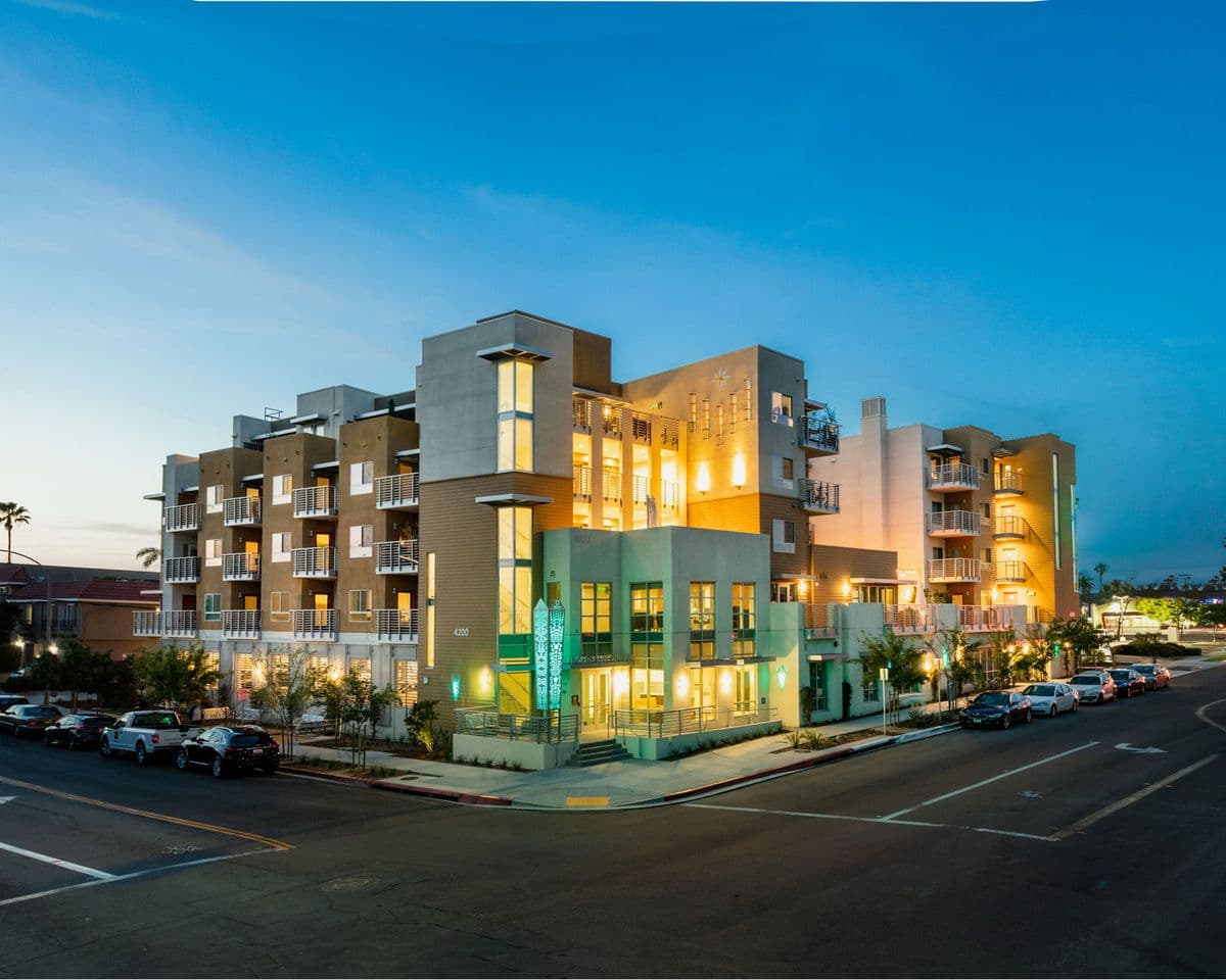 North Park Seniors at dusk, its windows and ground-floor community room lit from within.